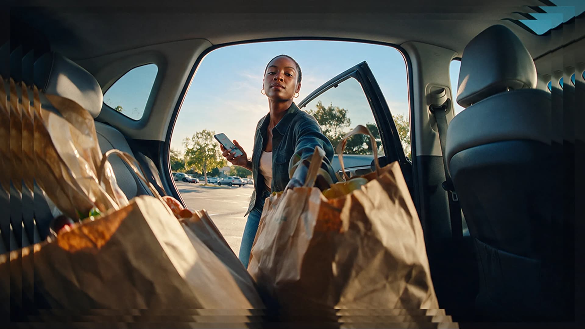 Woman loading grocery bags into a car, with a Neo Advance balance of $74.38 overlaid on the image.