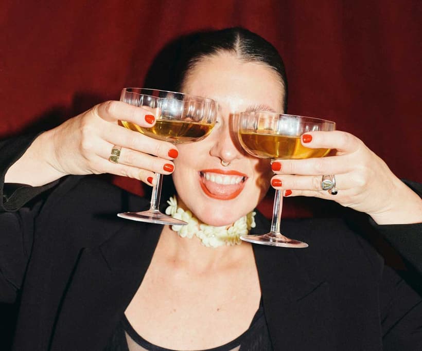 A Canadian woman happy and toasting her net worth, which she just calculated.