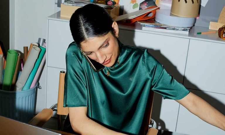 A Canadian woman on the phone negotiating paying $1,000 less a year for her phone and internet bundle.