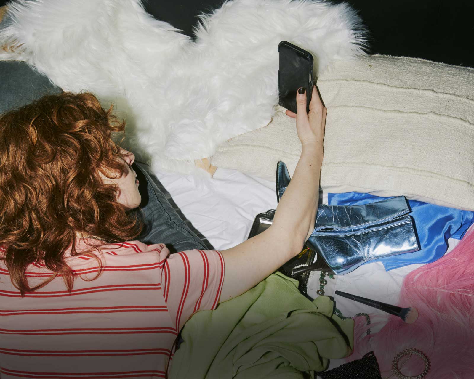 A Canadian woman, surrounded by her latest purchases, stares at her phone, wondering how to add friction to her shopping so she spends less money.