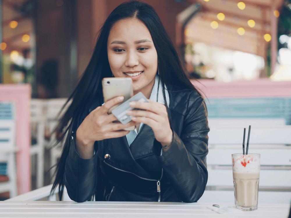 A Canadian woman who must made the minimum payment on her credit card, smiling, knowing that it won't put a negative mark on her credit score.