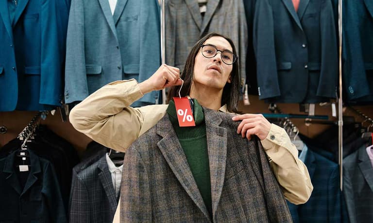 A Canadian man at the mall, trying to decide if he wants to buy a sweater and blazer with his disposable income.