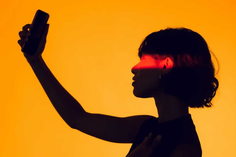 A Canadian woman searching online, lit in a way that shows she's hidden, but the bright background contrasts that questions the idea of online privacy.
