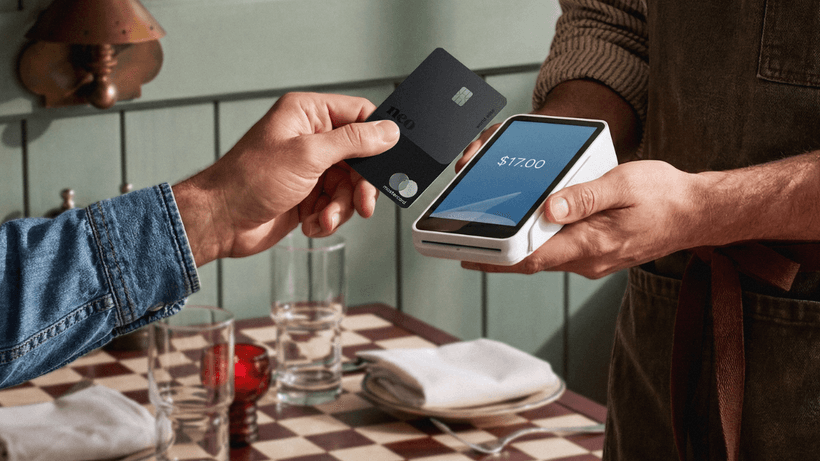 A person tapping to pay at a restaurant using the secured version of the Neo Mastercard, one of the best secured credit cards in Canada