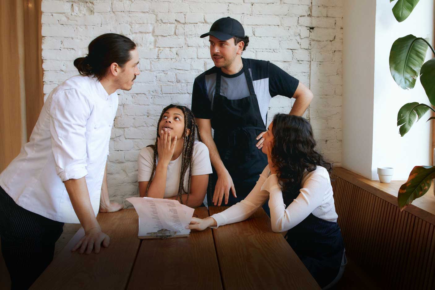 A group of Canadian restaurant kitchen staff and servers discussing if their boss is keeping their tips.