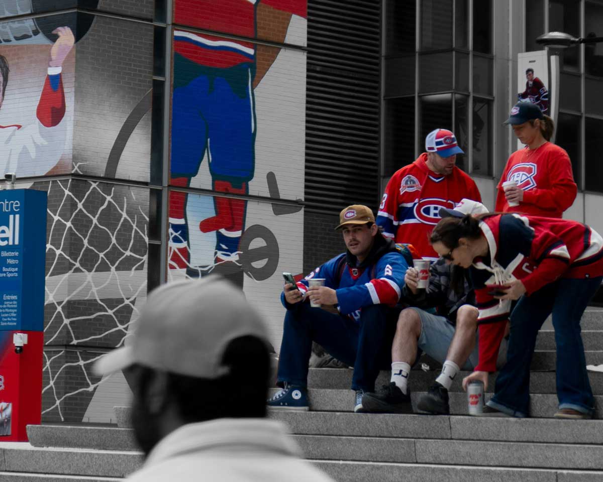 Montreal Habs fans sitting outside the Bell Centre sharing some food and drinks.
