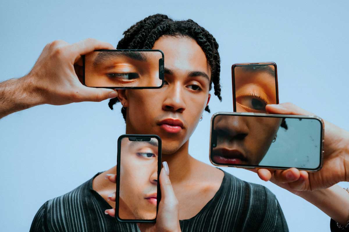 A man with his face on multiple phones, symbolizing the multiple accounts Canadians have online the impact it can have on family after a death.