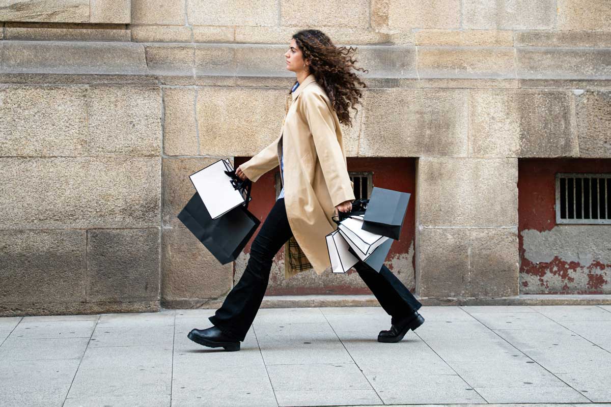 A Canadian woman walking down the street, carrying a shopping haul from her gift cards she forgot about. Find out if they expire.