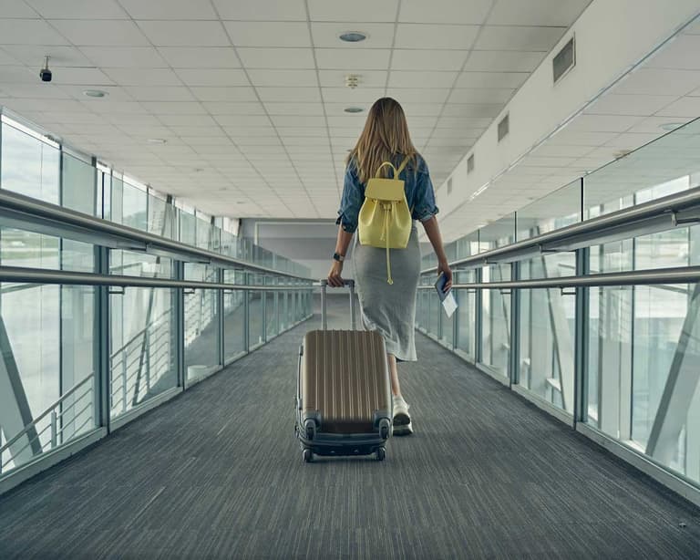 A Canadian traveller, boarding a plane, knowing that she has paid a fuel surcharge because of the price increases in jet fuel.