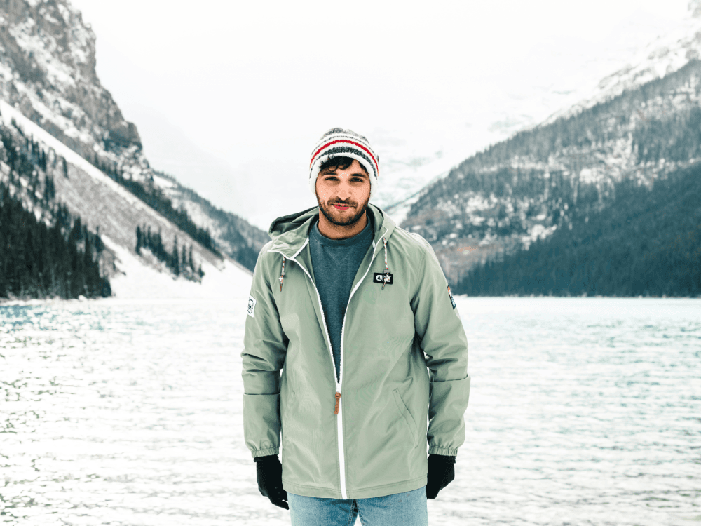 A Canadian man smiling in front of the picturesque Lake Louise, happy that he's made January suck less.