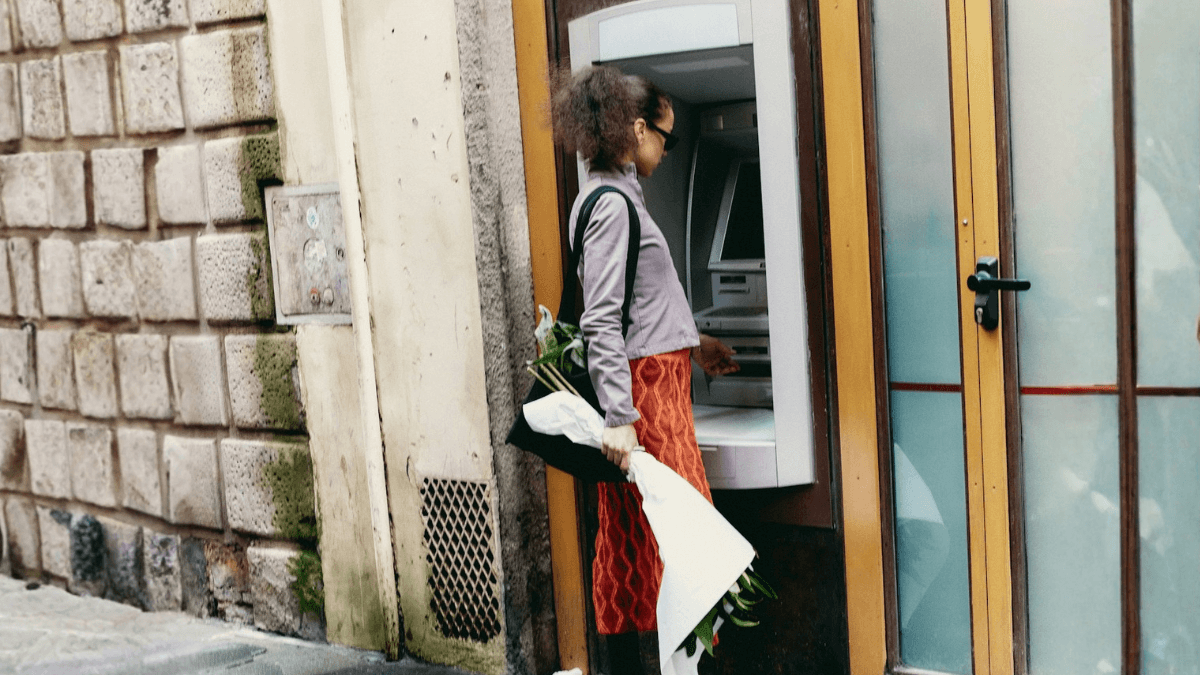 How to open a bank account as an international student in Canada: A student standing in front of an ATM