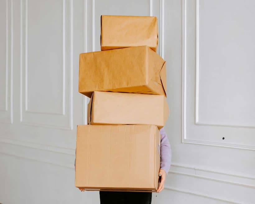 A Canadian hiding behind a tower of delivery packages, as they're shy about getting scammed from online shopping.