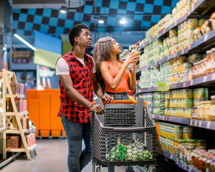 A Canadian couple, grocery shopping, looking for budget-friendly foods that don’t have inflation pricing.
