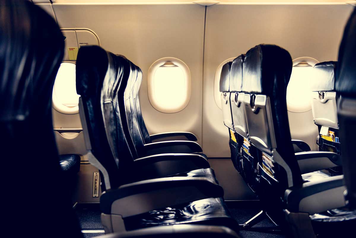 A view inside of an airplane showing seats that are clearly not first class, as we explore if premium economy is worth the upgrade.