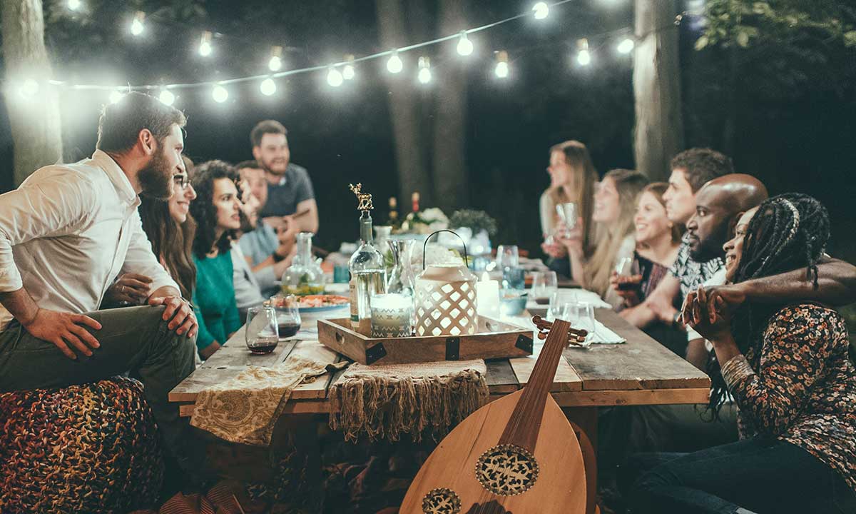 A group of Canadian couples at a dinner party in a backyard, showing the range of relationships and financial behaviours.