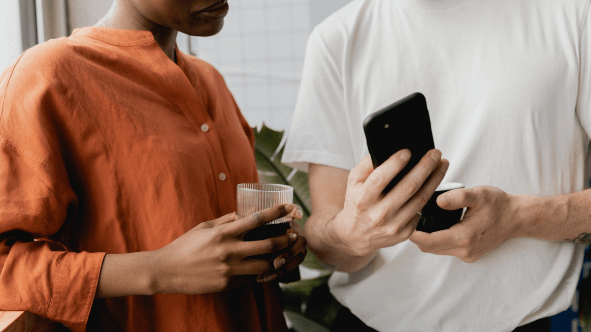 Two people looking at a phone screen as they decide to open a no-fee joint account in Canada