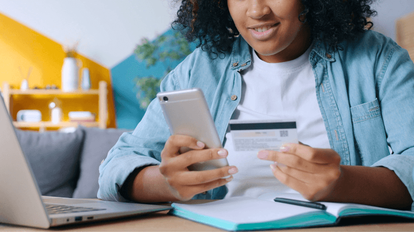 A person holding a credit card and smartphone in their hands