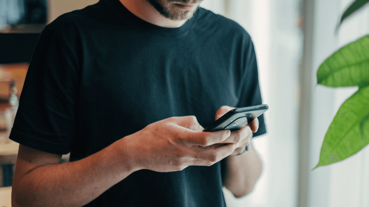 A Canadian checking their banking app on their phone, confused by the meaning of "outstanding balance" on their credit card