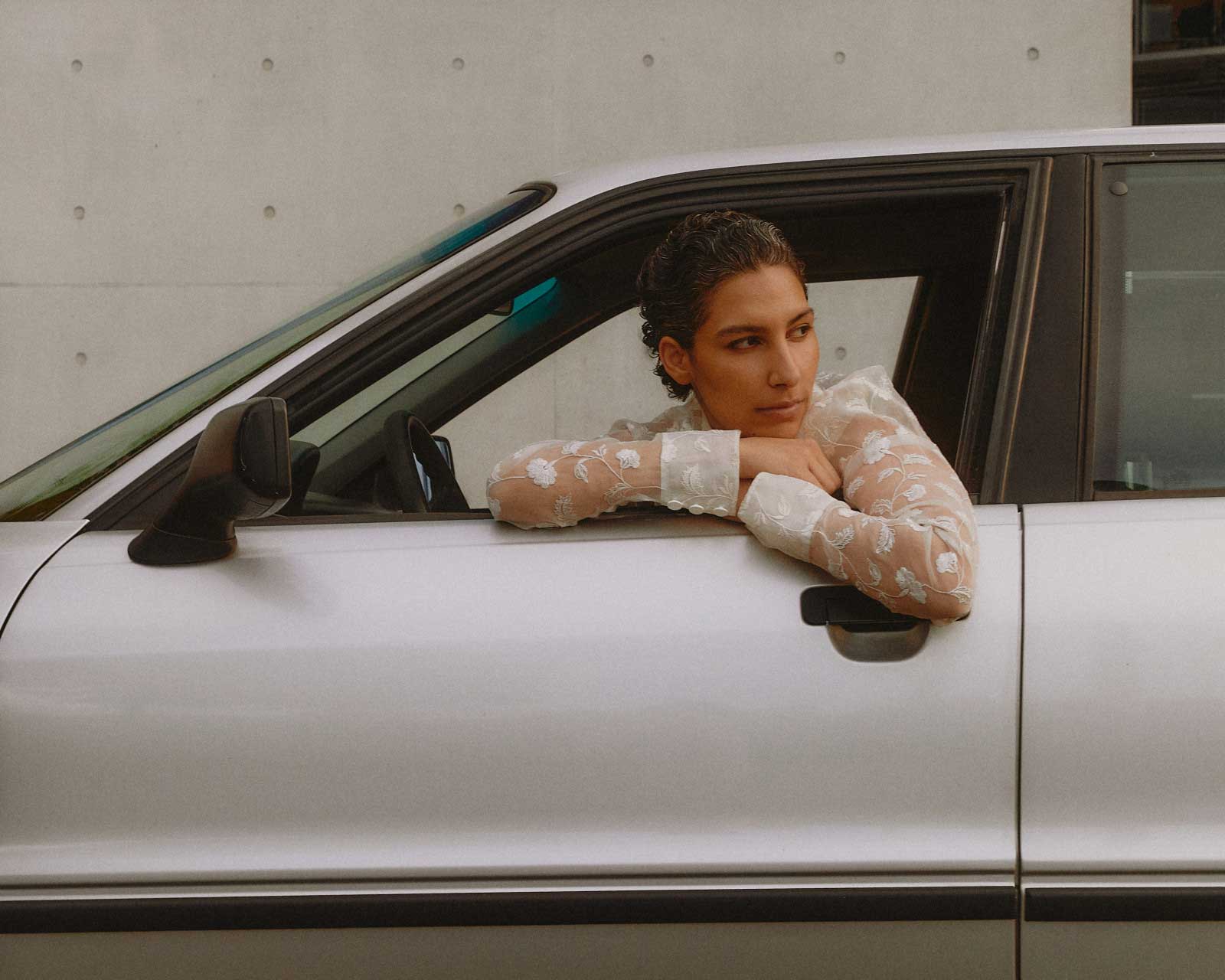 A Canadian driver, sitting in the car, wondering if they should opt out of add-on policies to save on auto insurance costs.