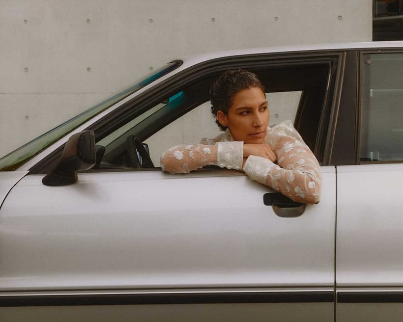 A Canadian driver, sitting in the car, wondering if they should opt out of add-on policies to save on auto insurance costs.