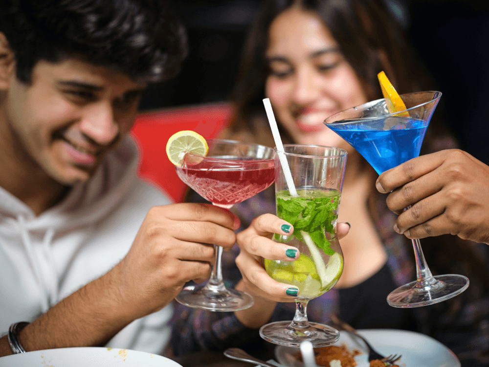 A group of Canadian friends clinking non-alcoholic drinks to save money
