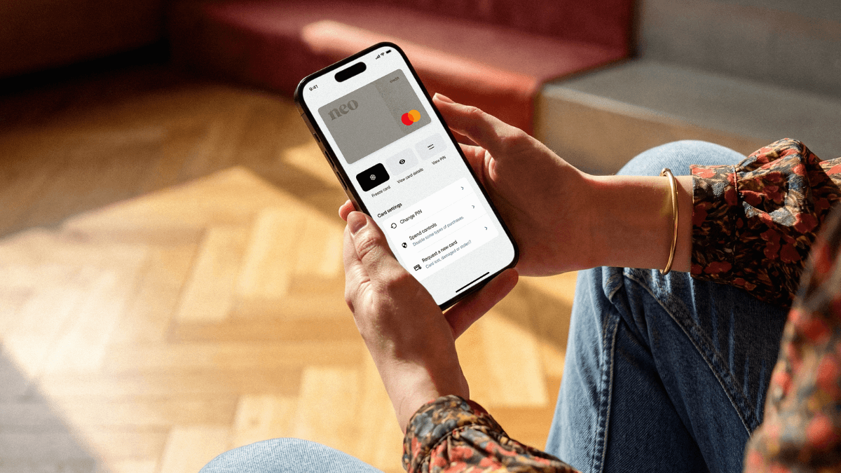 A person using the Neo app on their smartphone to check how they can get a secured credit card limit increase in Canada