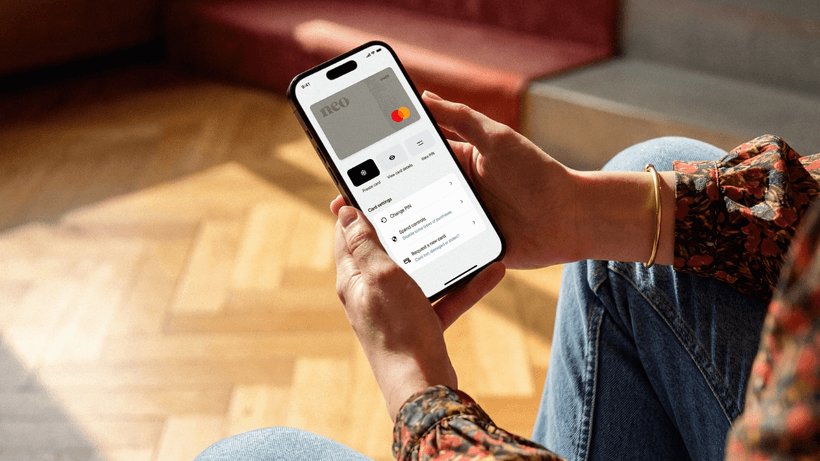 A person using the Neo app on their smartphone to check how they can get a secured credit card limit increase in Canada