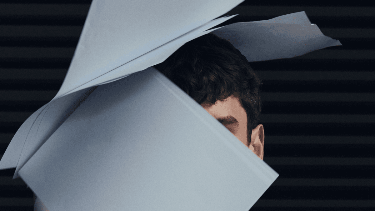 Sheets of paper falling over a person's head, representing the truth about government debt relief programs in Canada