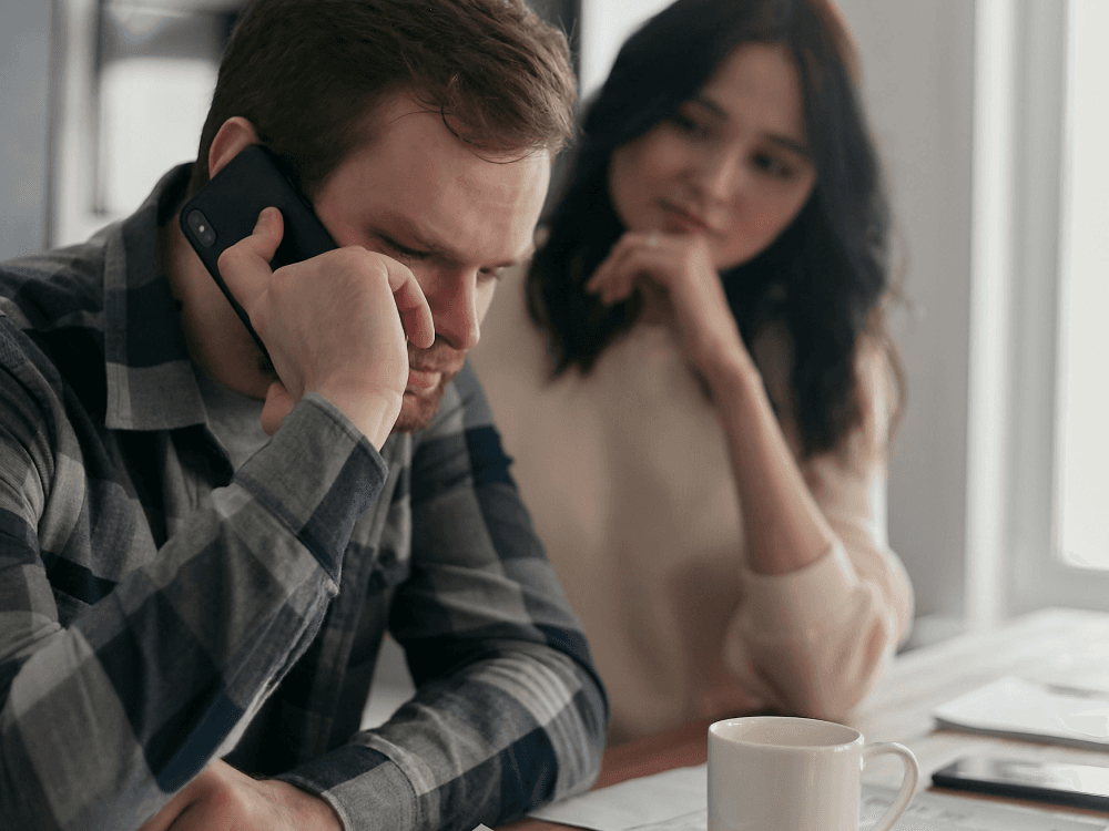 A Canadian couple on the phone with customer service, trying to figure out if they're paying junk fees.