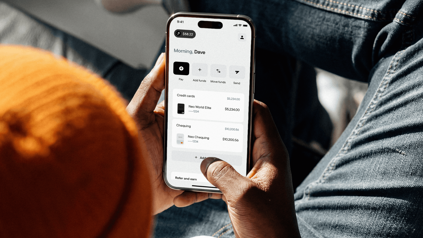 A Canadian using their smartphone to access the Neo app, where they are monitoring the accounts and cards they have with their Neo membership