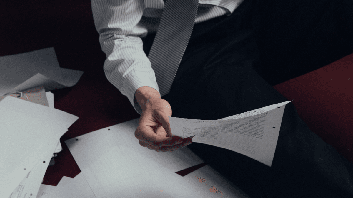 A person in debt holding up a sheet of explaining what a debt collection agency can do in each province in Canada