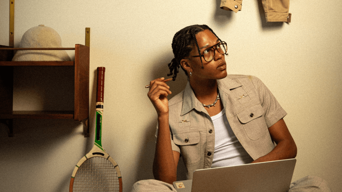 A person sitting with their back against a wall, research "what is a cash advance" on their computer