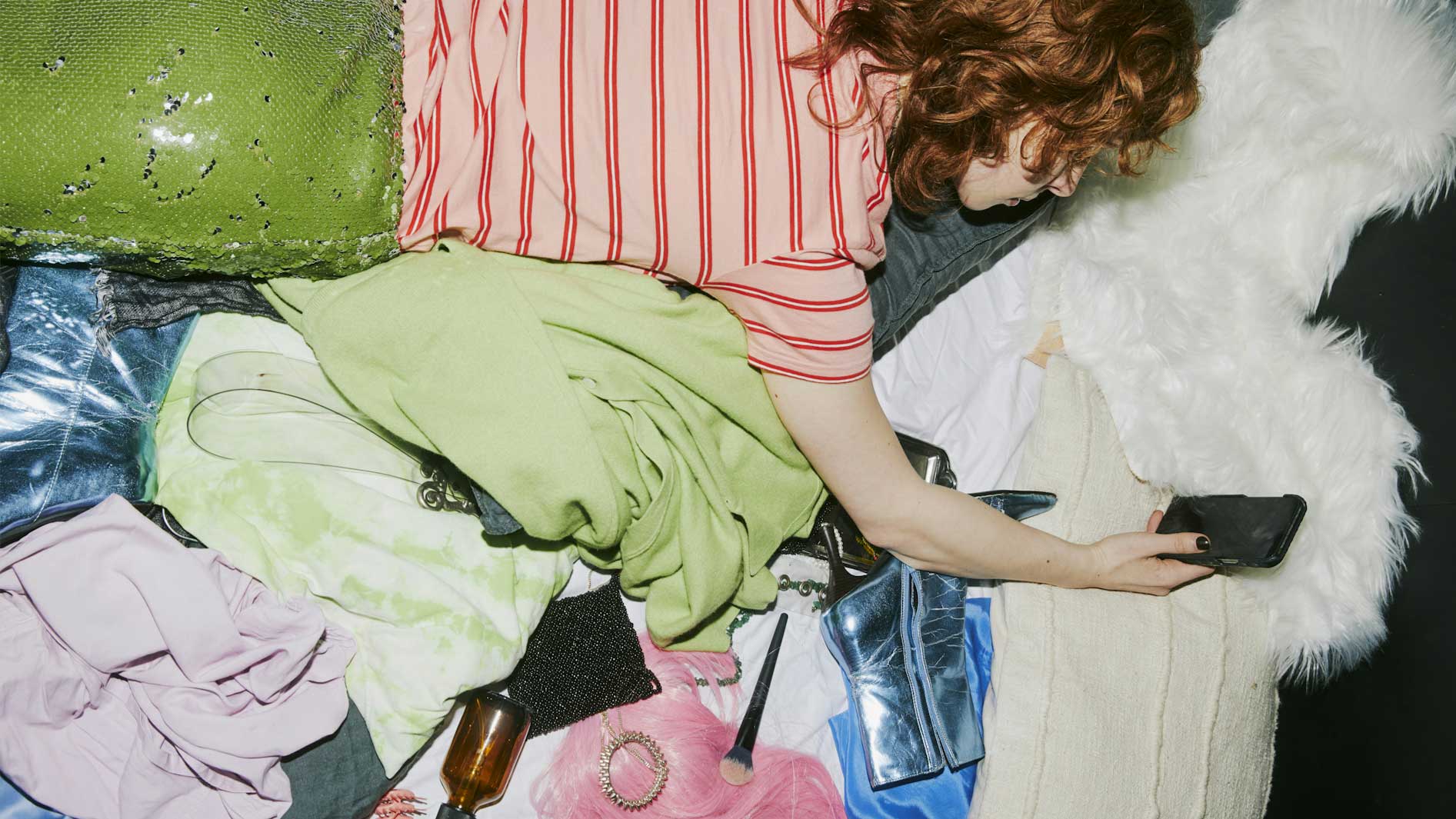 A Canadian woman looking at TikTok on her phone, surrounding by the things she's influenced to buy.