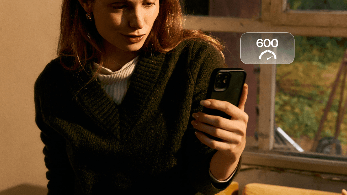 A person using their smart phone, checking what they can and can't do with a 600 credit score in Canada.