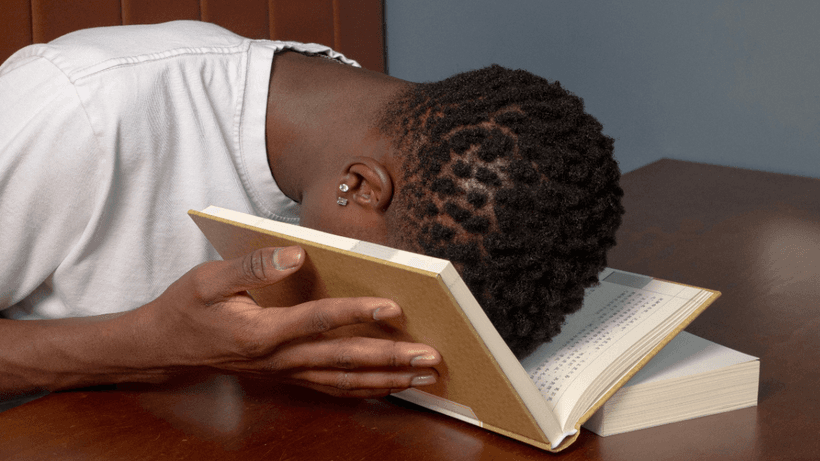 A person burying their face in a book, wondering why their credit score dropped in Canada