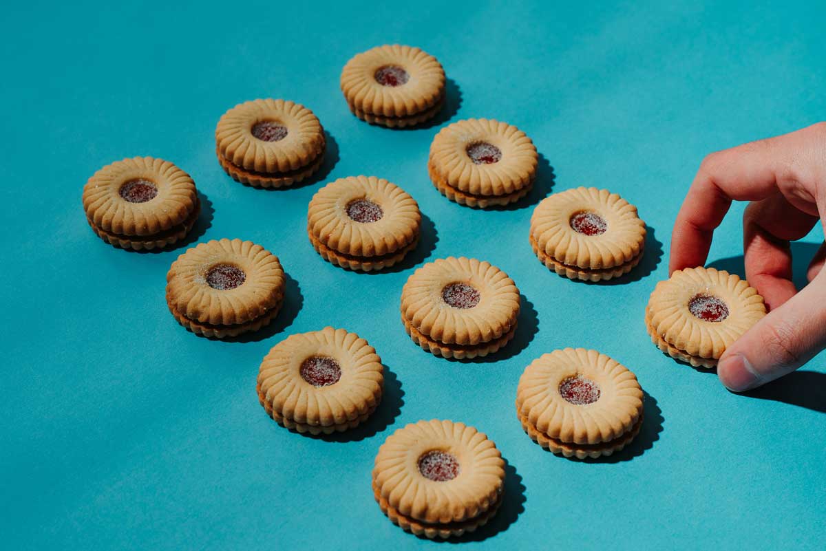 A hand reaching out for a Peak Frean cookie (a Canadian cookie staple), all to symbolize why hackers and scammers are stealing Canadians internet cookies.